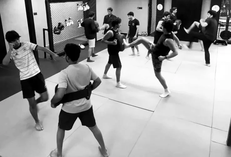 Members kicking pads held by partners